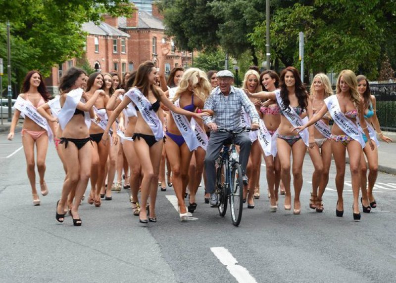 Old Man on Bike Surrounded by Beauty Pageant Contestants 1360851116.jpg